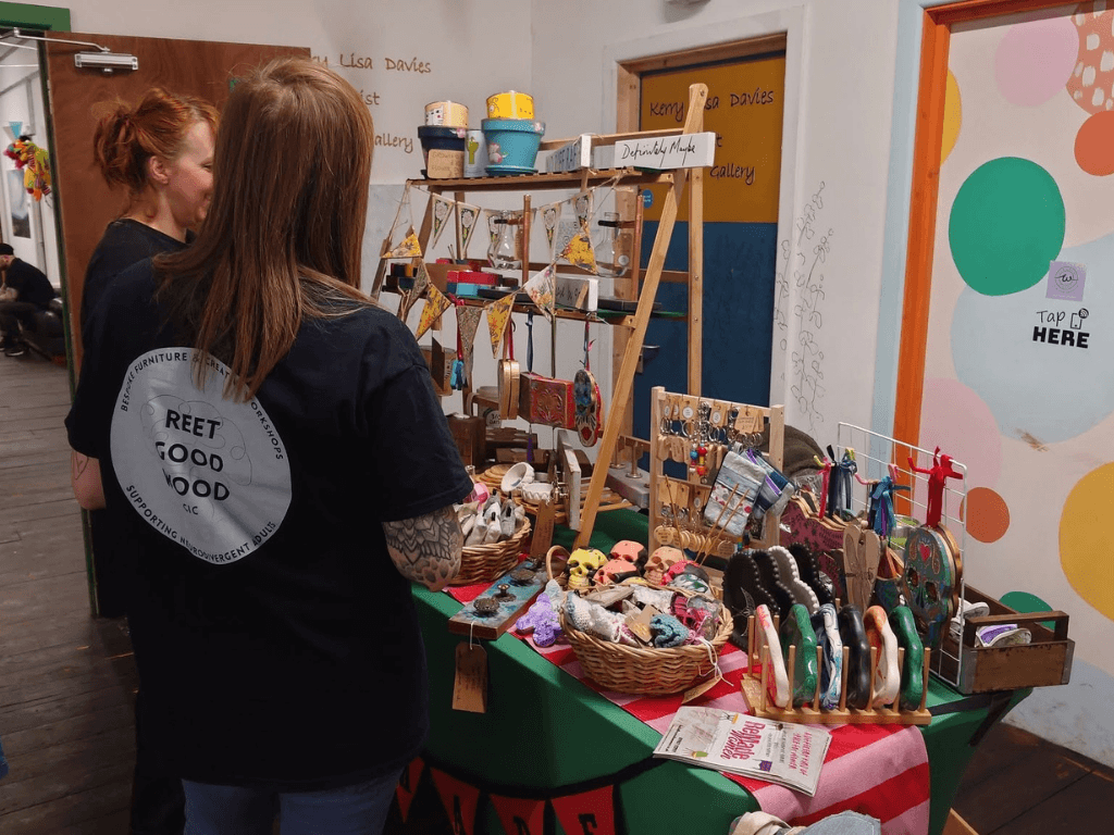 Visitors browsing handmade crafts, jewellery and artisan products at a makers market stall inside Leigh Spinners Mill.