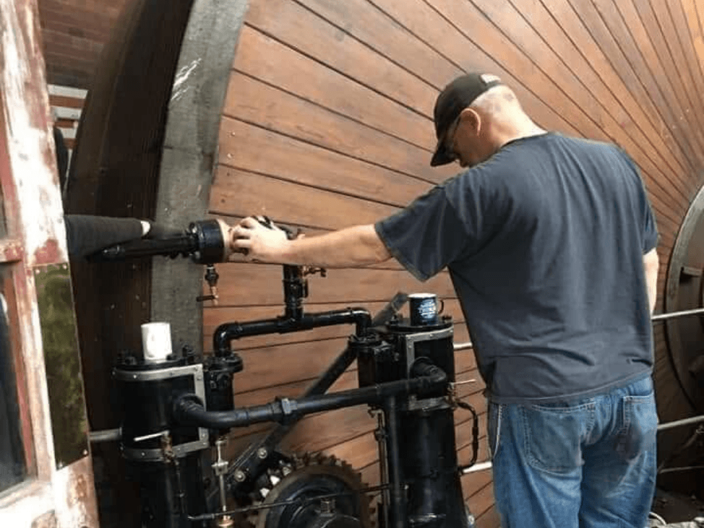 Volunteer carrying out maintenance work on one of the historic steam engines at Leigh Spinners Mill Heritage Centre.