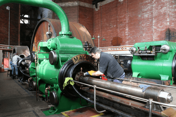 Volunteers working on the restored Mayor & Mayoress steam engine at Leigh Spinners Mill, highlighting the preservation of the 1,800 horsepower engine.