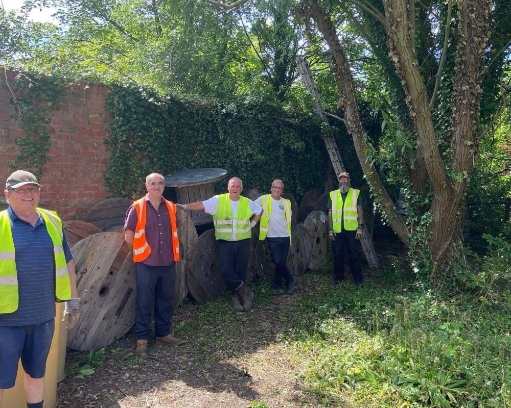Volunteers working in the outdoor grounds at Leigh Spinners Mill, helping to maintain and improve the site as part of ongoing community and heritage projects.
